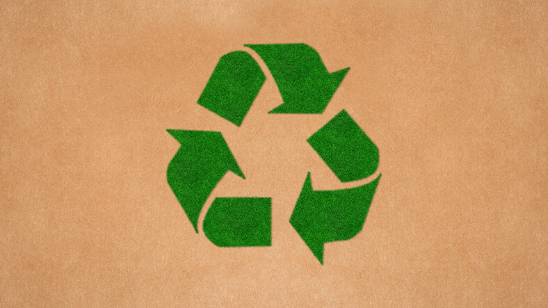 green recycling symbol on tan textured background